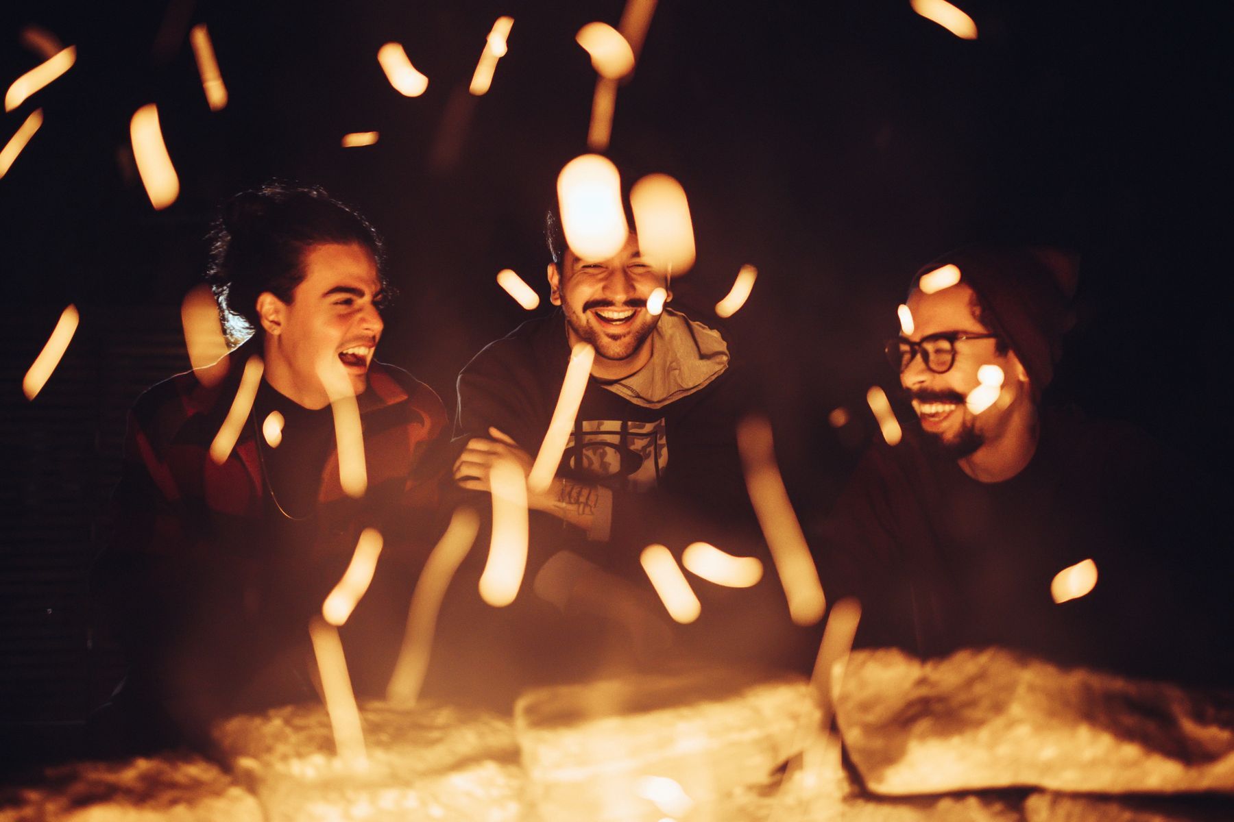 Friends laughing by a fire